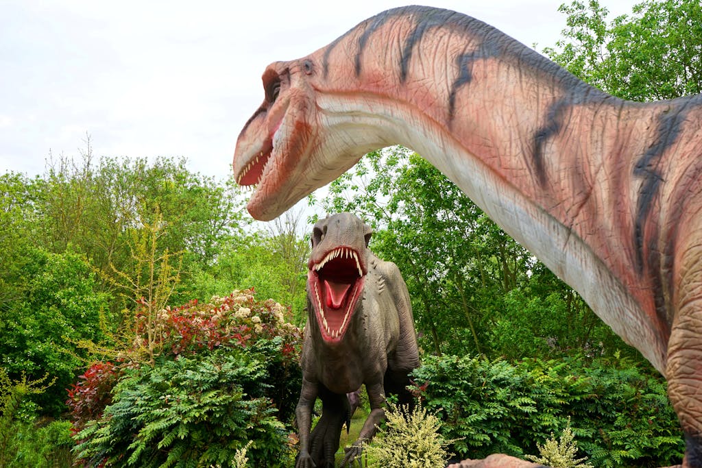 Realistic dinosaur sculptures in a lush park setting, evoking prehistoric times.